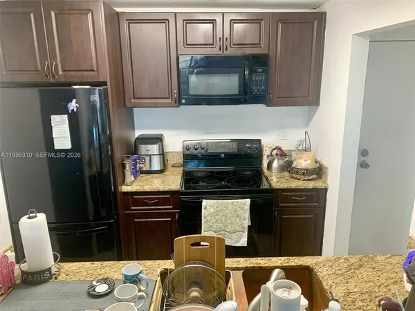 a kitchen with granite countertop cabinets stainless steel appliances and a sink