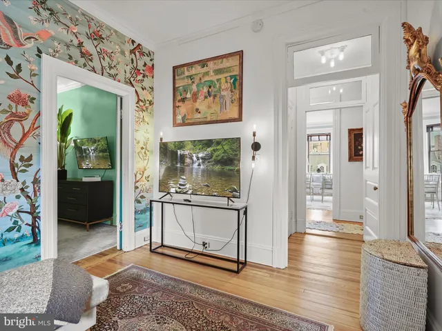 a view of a hallway with wooden floor and a living room