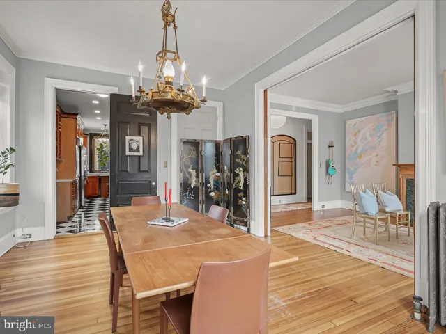 a view of a dining room and livingroom with furniture wooden floor a chandelier