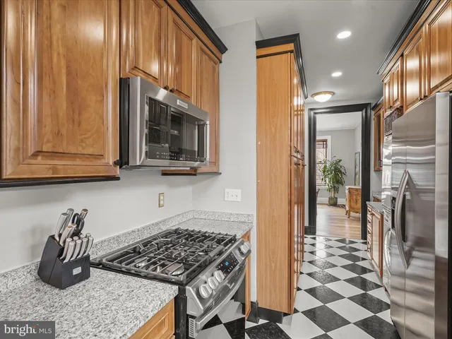 a kitchen with stainless steel appliances granite countertop a refrigerator and a sink