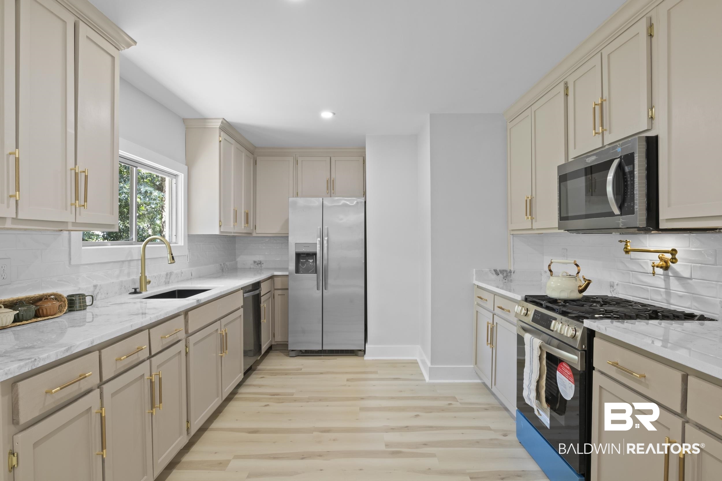 315 Park Avenue Mobile, AL 36607 - Photo 15 of 27 Kitchen with decorative backsplash, appliances with stainless steel finishes, light stone countertops, light hardwood / wood-style flooring, and sink
