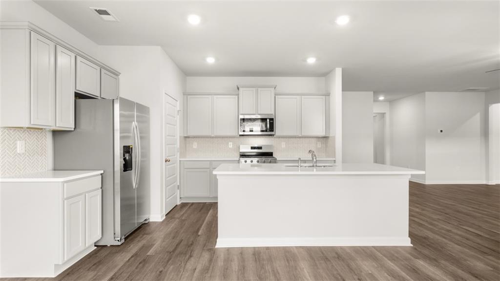 200 Defilippe Drive Statham, GA 30666 - Photo 10 of 60 a kitchen with stainless steel appliances granite countertop a refrigerator a stove a sink and white cabinets with wooden floor