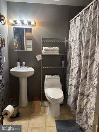 a bathroom with a sink toilet and a mirror