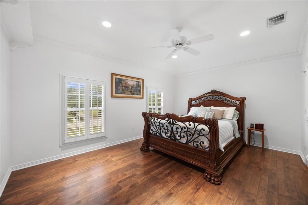 506 Meadowview Road Heath, TX 75032 - Photo 21 of 32 a bedroom with a bed and wooden floor