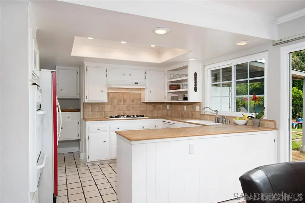 2022 Sheridan Road Encinitas, CA 92024 - Photo 7 of 25 a kitchen with stainless steel appliances a stove a sink a refrigerator and cabinets