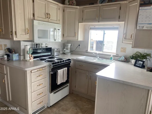 a kitchen with cabinets appliances a sink and a window