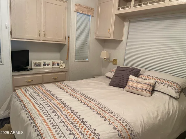 a bedroom with a bed and a flat screen tv