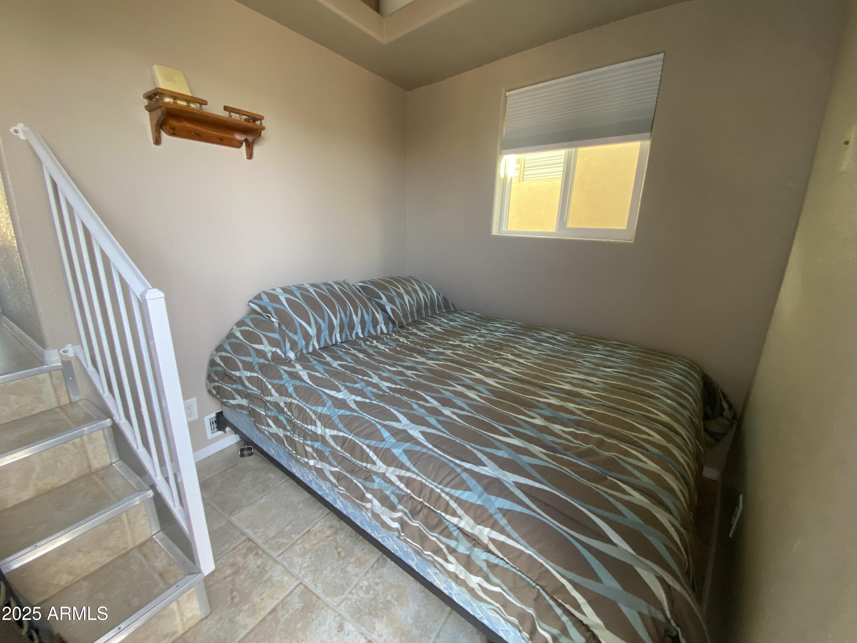 2355 South Pomo Avenue Apache Junction, AZ 85119 - Photo 26 of 32 a bedroom with a bed and a window