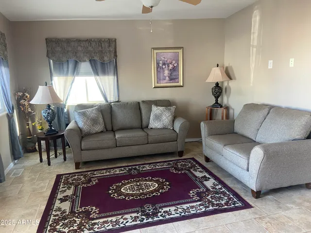 a living room with furniture a rug and a window