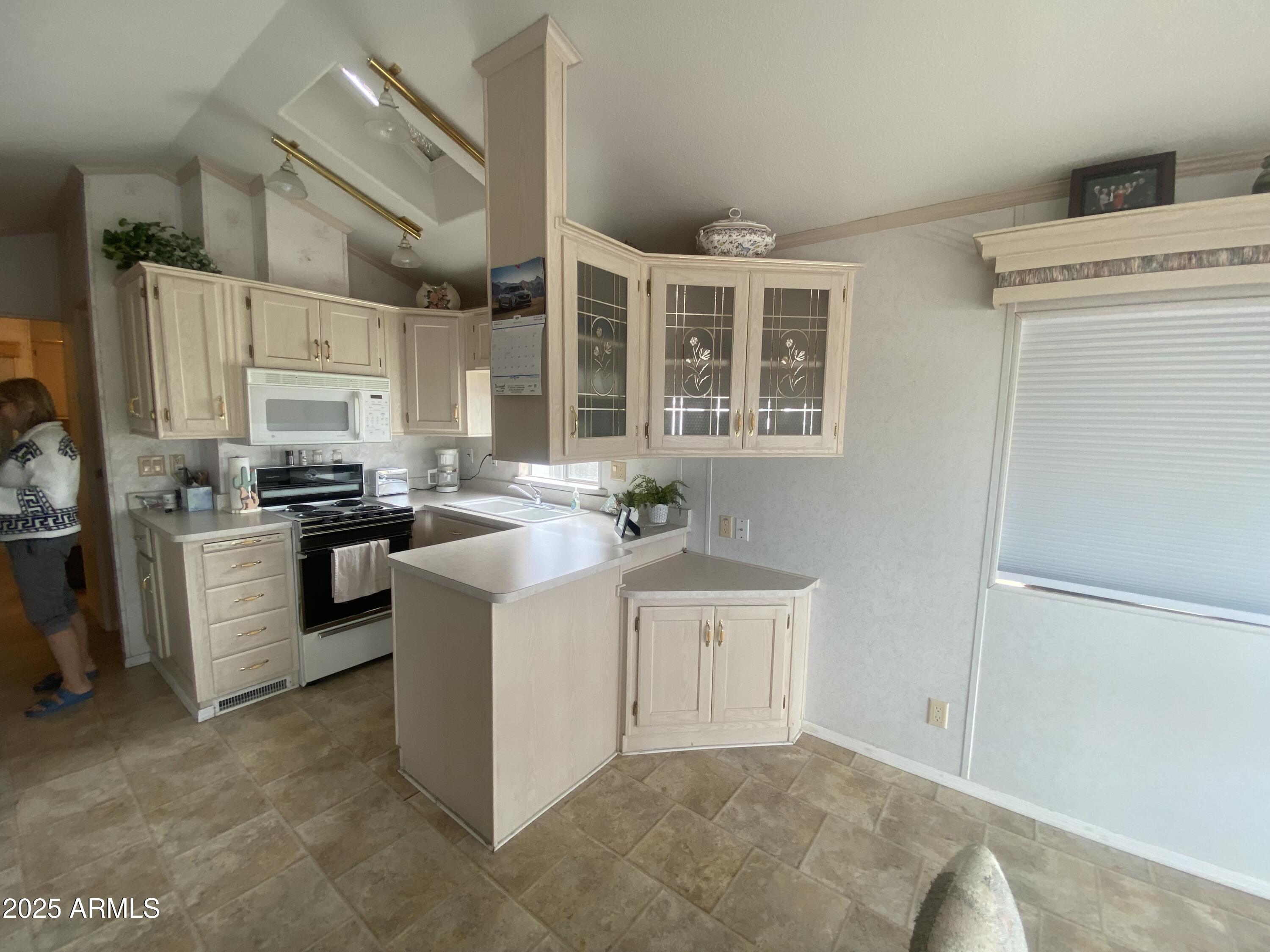 2355 South Pomo Avenue Apache Junction, AZ 85119 - Photo 8 of 32 a kitchen with white cabinets and white appliances