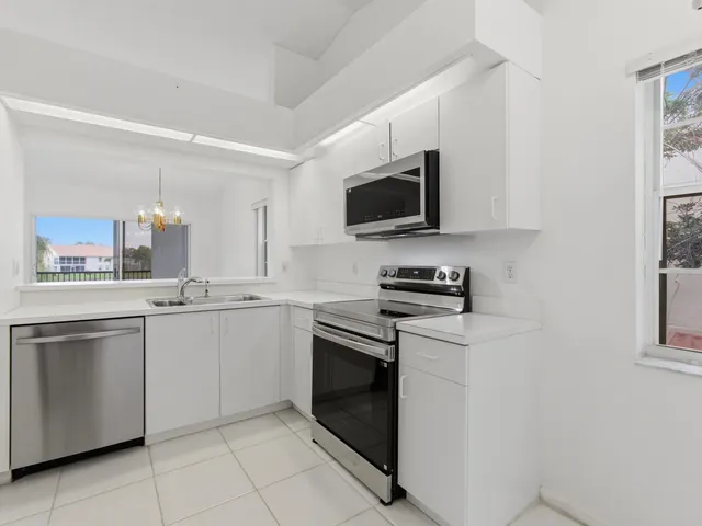 an aerial view of a house with a yard and a large tree