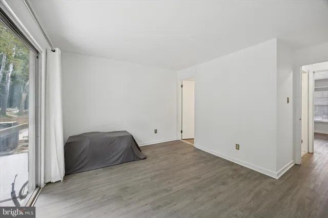 a view of room with wooden floor and windows