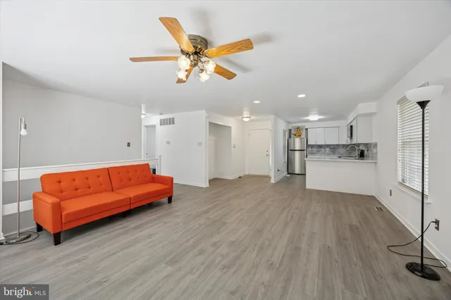 a living room with furniture and kitchen view