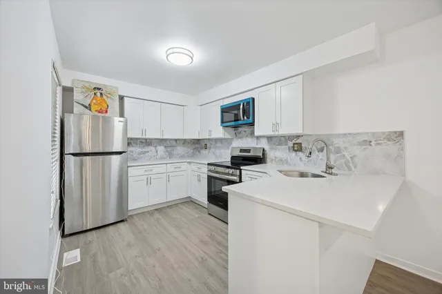 a kitchen with white cabinets and white appliances