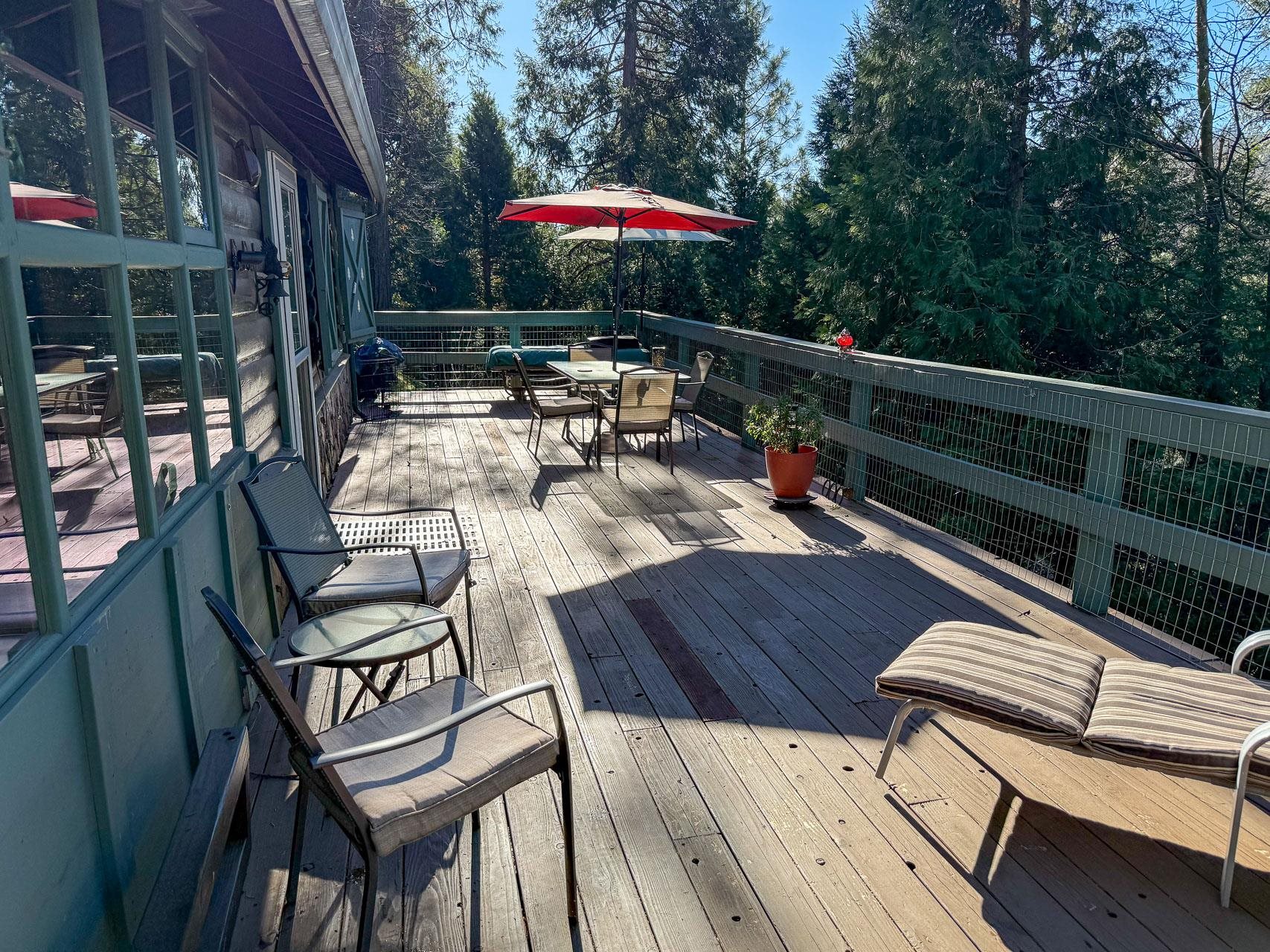 21819 Confidence Road Twain Harte, CA 95383 - Photo 15 of 15 a view of a roof deck with table and chairs under an umbrella with wooden floor