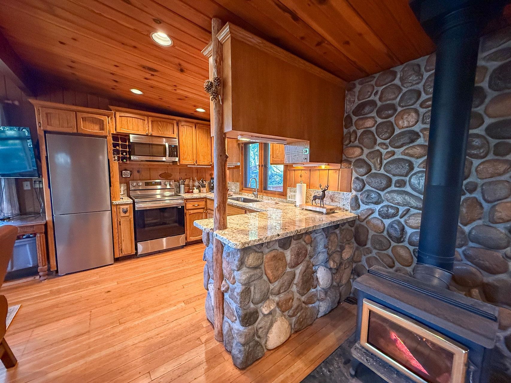 21819 Confidence Road Twain Harte, CA 95383 - Photo 9 of 15 a kitchen with stainless steel appliances kitchen island granite countertop a stove and a refrigerator