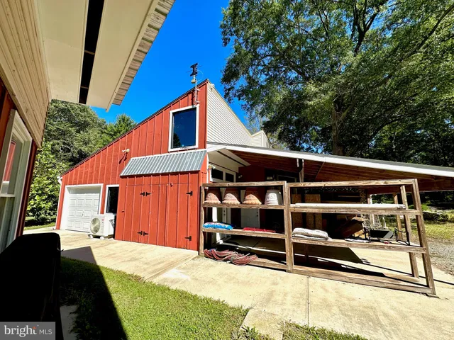 a backyard of a house with wooden fence and large trees