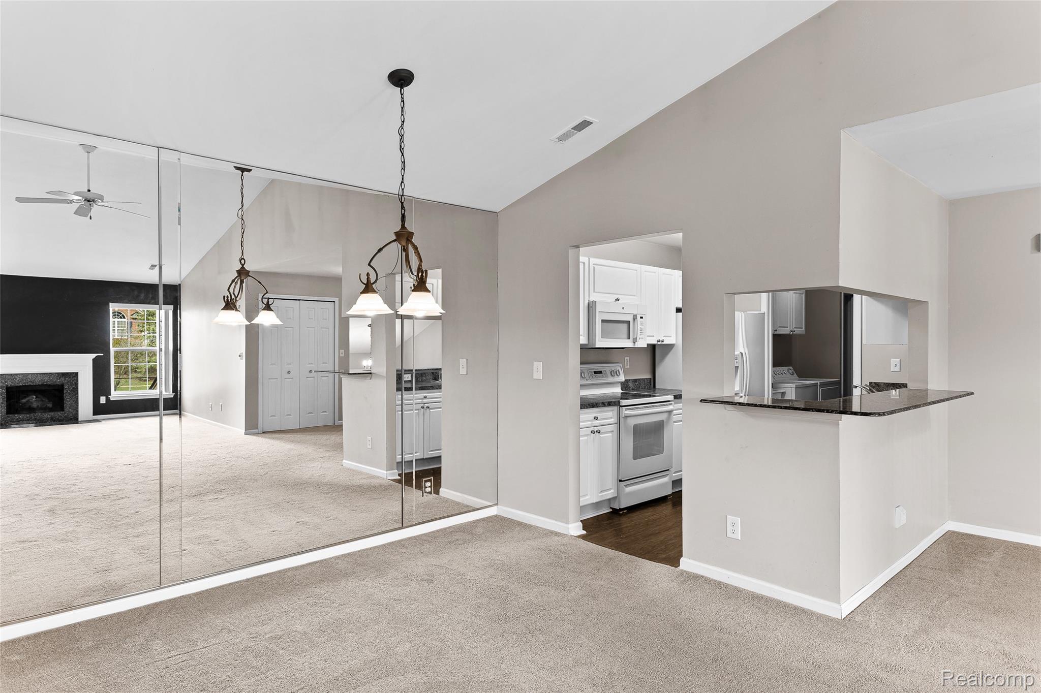 3553 Oakmonte Boulevard Rochester, MI 48306 - Photo 10 of 42 Living area featuring a mirrored wall, carpet flooring, and a ceiling fan
