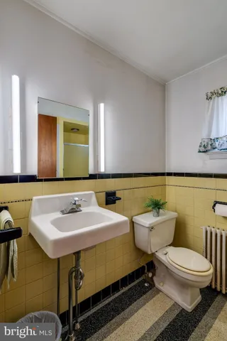 a bathroom with a toilet sink and mirror