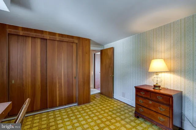 a bedroom with a bed and a lamp on dresser
