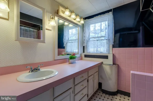 a bathroom with a sink a mirror and a window