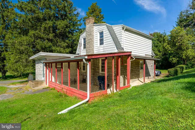 a view of a house with a yard and a large tree