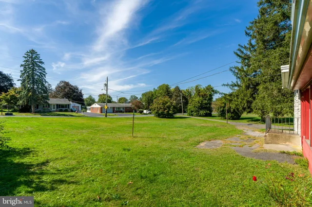 a view of a house with backyard and trees