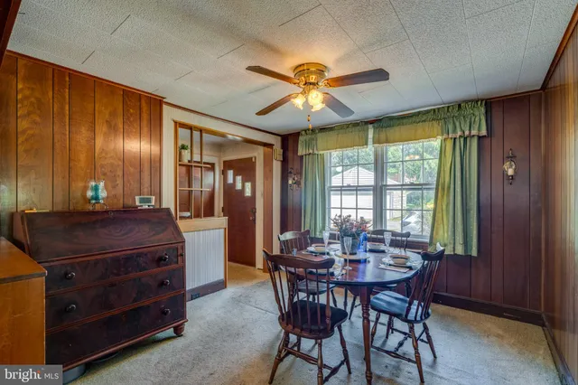 a dining room with a wooden table and chairs