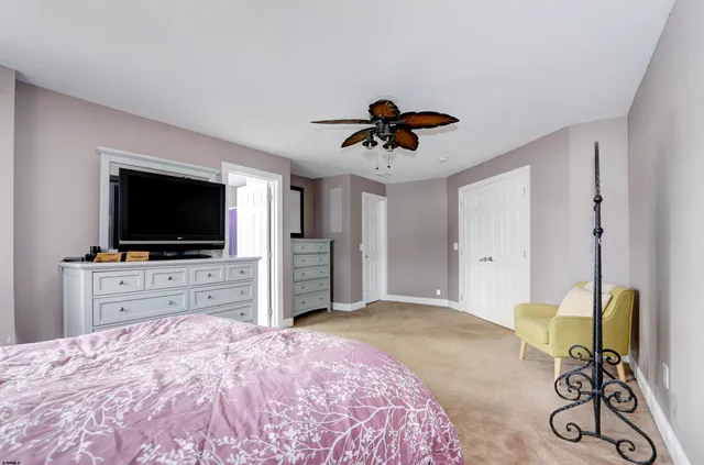 a bedroom with a bed and a flat tv screen on dresser