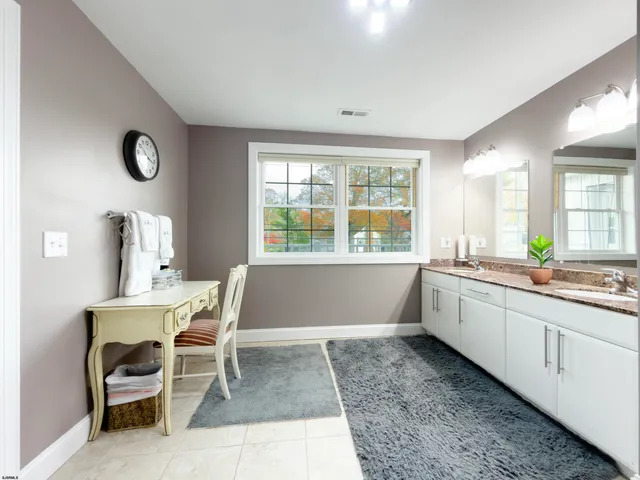 a large white kitchen with a window and chair