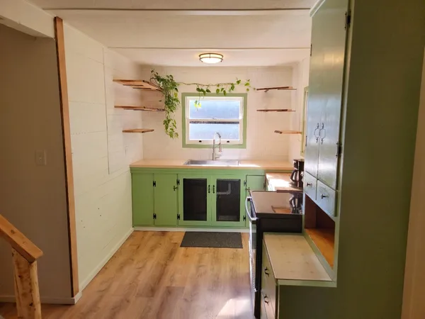 a view of a hallway with furniture and a window