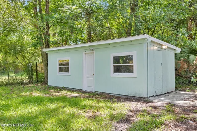 a view of a house with yard and a tree