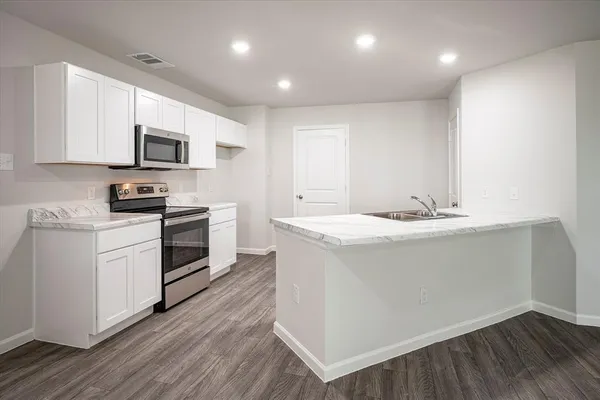 a kitchen with granite countertop a sink and steel appliances