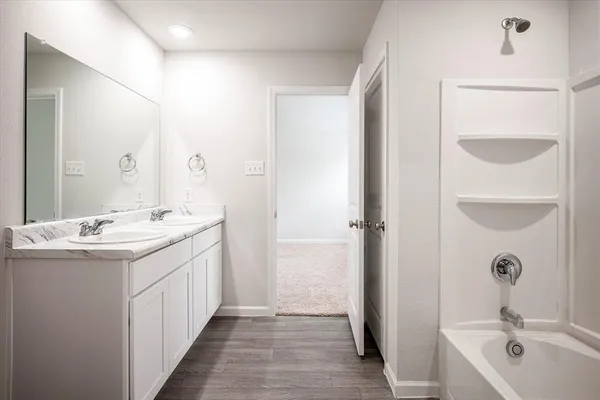 a bathroom with a double vanity sink and a bathtub