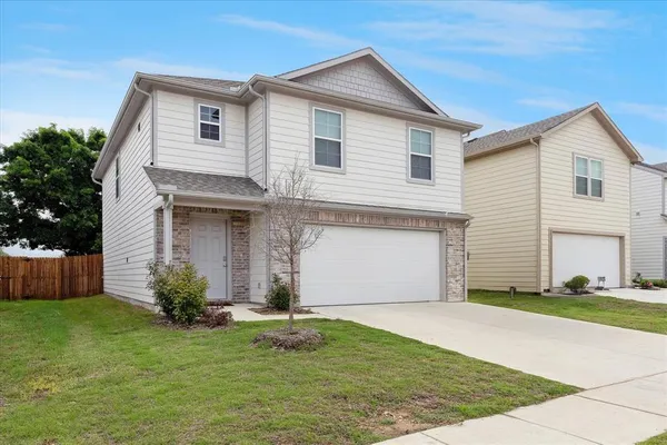 a front view of house with yard and garage