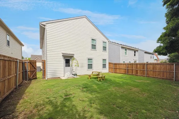 a view of a house with backyard and porch with wooden fence