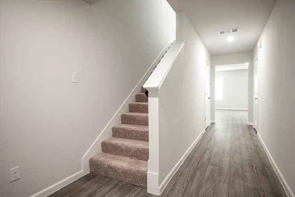 a view of a hallway with wooden floor and entryway