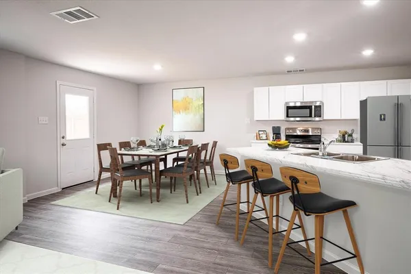 a view of kitchen with cabinets table and chairs