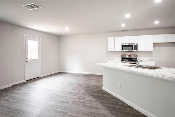 a kitchen with granite countertop a sink and cabinets