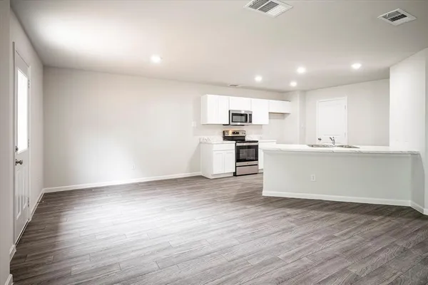 a view of kitchen with wooden floor and electronic appliances