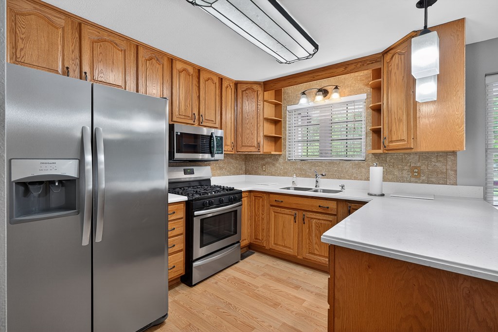80 Sowers Road Blue Ridge, GA 30513 - Photo 13 of 58 a kitchen with stainless steel appliances granite countertop a refrigerator a sink dishwasher a stove and white countertops with wooden floor