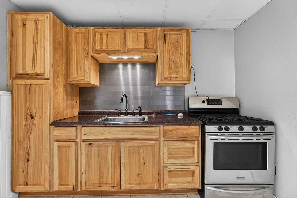 80 Sowers Road Blue Ridge, GA 30513 - Photo 34 of 58 a kitchen with granite countertop a stove and a wooden cabinets