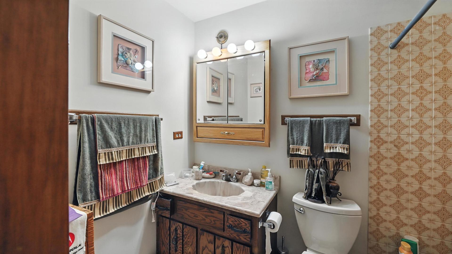953 Surrey Road Addison, IL 60101 - Photo 12 of 21 a bathroom with a toilet a sink and a mirror