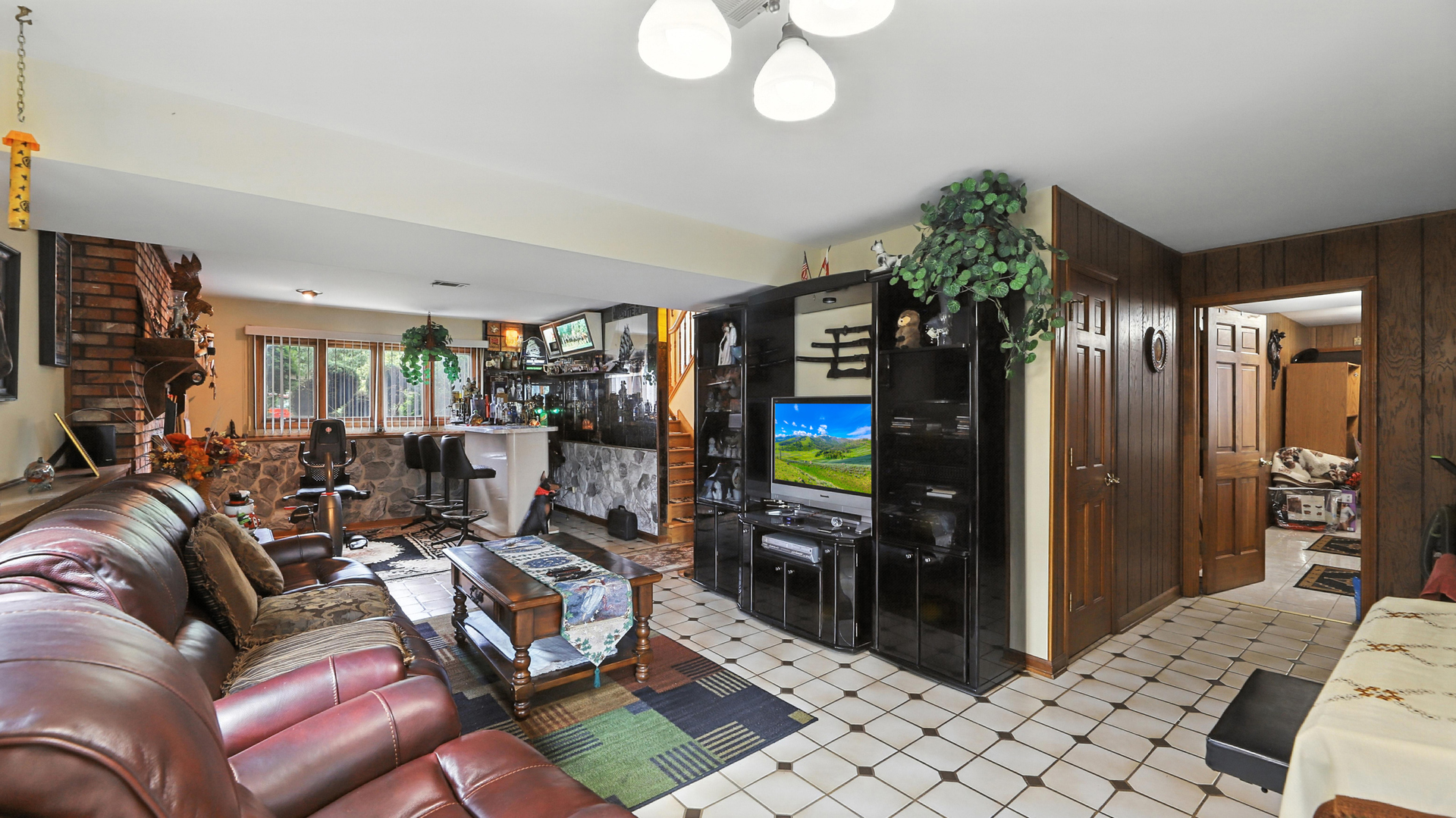 953 Surrey Road Addison, IL 60101 - Photo 15 of 21 a living room with furniture a chandelier and a flat screen tv