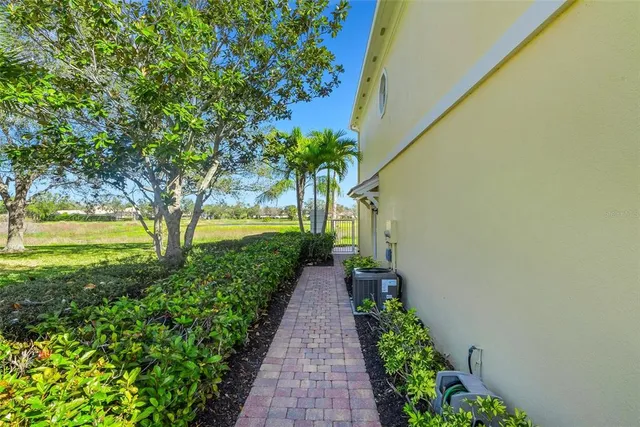 front view of house with a yard and palm trees