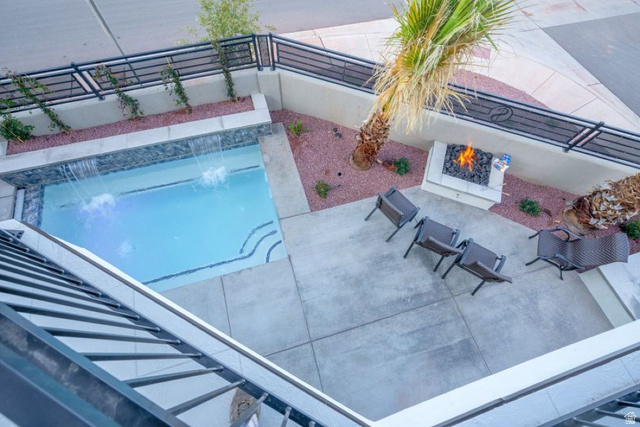2600 Ocotillo Way, Unit 31 Santa Clara, UT 84765 - Photo 68 of 73 Outdoor patio featuring a rectangular swimming pool with waterfall features, a built-in fire pit, and concrete hardscaping