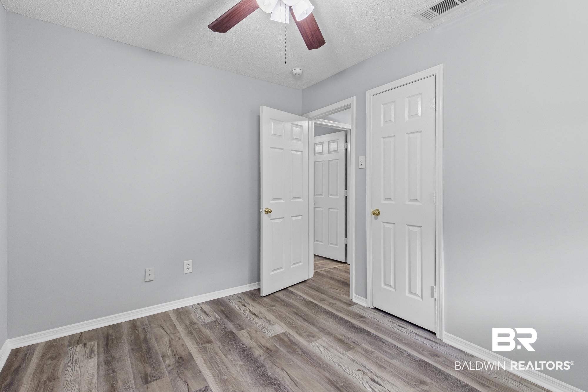 6933 Burbank Court Mobile, AL 36619 - Photo 21 of 25 Room featuring wood-finish flooring, light grey walls, and white baseboards