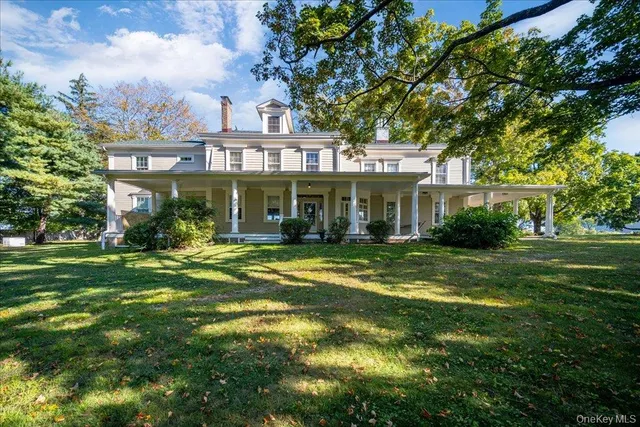 a view of a patio with table and chairs potted plants and large tree