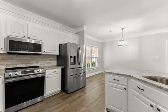 an empty room with wooden floor fireplace and windows
