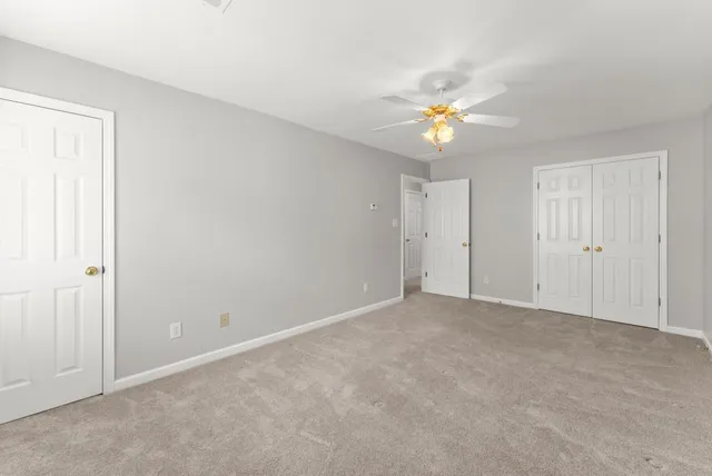 a view of backyard with wooden fence and a large tree